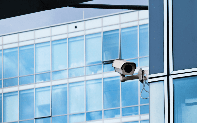 AI-powered security camera mounted on a modern office building, representing advanced surveillance solutions for commercial real estate. Smart surveillance and live security monitoring help prevent unauthorized access and enhance office building security.