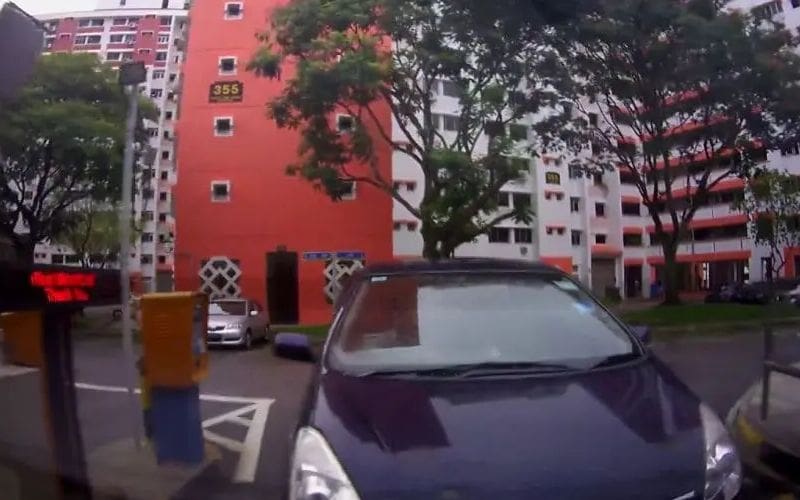 A security camera captures a person tailgating into an apartment building, illustrating the dangers of unauthorized access. The image highlights a common security risk where individuals sneak in behind residents without key fob authentication. Prevent tailgating with AI-powered video surveillance and live monitoring solutions like EyeQ Virtual Guard to enhance apartment security.