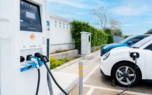 Electric vehicles charging at a public EV station under a clear blue sky. AI-powered security solutions help protect charging infrastructure from theft, vandalism, and cyber threats, ensuring a safe experience for drivers.