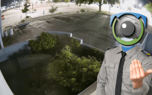 Virtual guard with surveillance camera head standing in a dimly lit parking lot, emphasizing the limitations of night vision cameras and the need for proactive commercial security solutions.