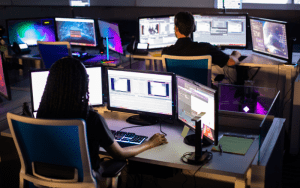Security operations center agents actively monitoring and verifying alerts on multiple screens, exemplifying EyeQ’s rapid response SLA commitment in live video monitoring and threat detection.