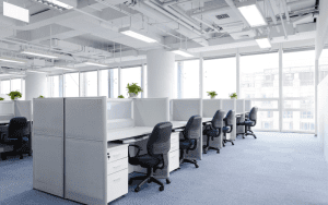 An empty, well-lit office space with cubicles, illustrating the importance of vacant property security to prevent unauthorized access or damage.