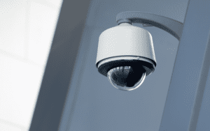 Close-up of a modern dome security camera mounted on a wall inside a commercial building, emphasizing its sleek design and positioning for indoor video monitoring.