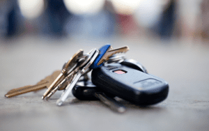 Close-up of a set of car keys and house keys lying on the ground, suggesting they were lost or dropped