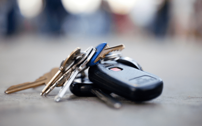 Close-up of a set of car keys and house keys lying on the ground, suggesting they were lost or dropped