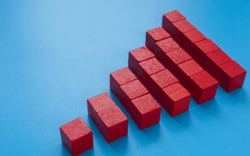 Red building blocks arranged in ascending order on a blue background, representing scalable growth or an upward business trend in security infrastructure.