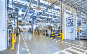Modern factory interior with machinery and wide walkways, showcasing an ideal environment for industrial CCTV security systems to enhance real-time monitoring, safety compliance, and threat prevention.
