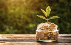 Jar filled with coins growing a plant symbolizing cost savings with remote guarding security