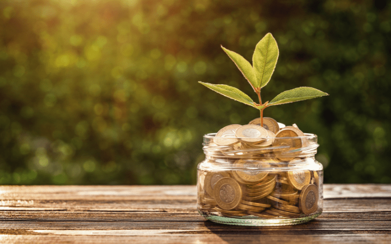 Jar filled with coins growing a plant symbolizing cost savings with remote guarding security