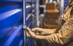 Person unlocking a blue storage unit with keys representing why security at self storage is important for protecting belongings and tenant trust.