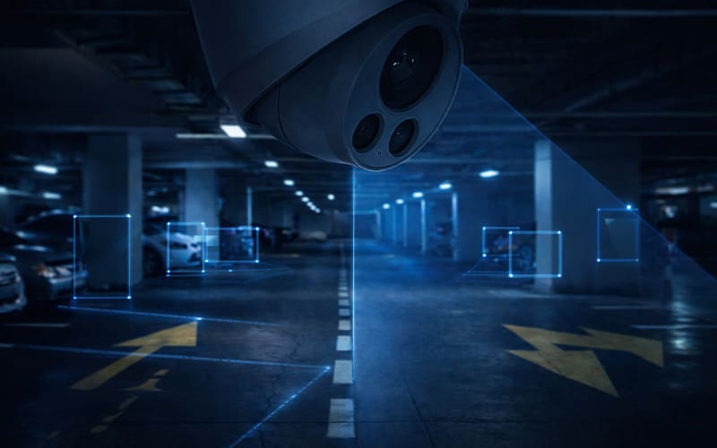 AI-powered commercial security camera monitoring a parking garage with smart detection zones and real-time video surveillance overlays